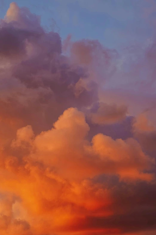 airplane flying into sunset with dramatic cloud formation