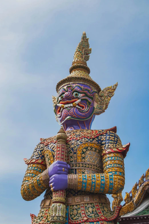 a large statue of a masked person is standing outside