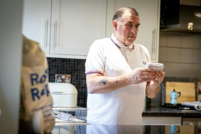 a man in a white apron using a cell phone