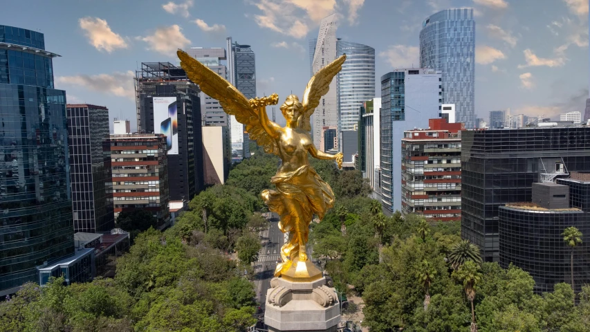 a very big golden statue in the middle of a city