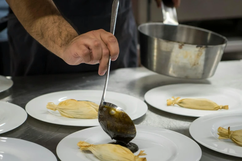 a chef scooping food from plates with utensils