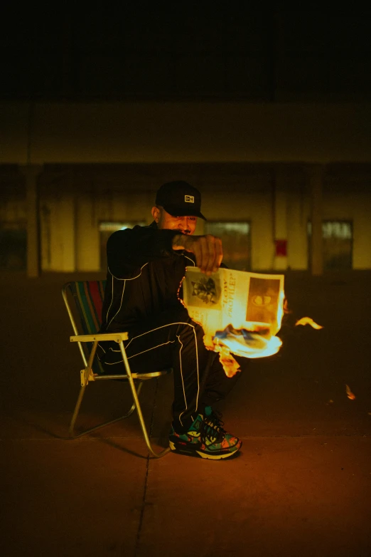 a man sits outside in the dark with his back to a camera