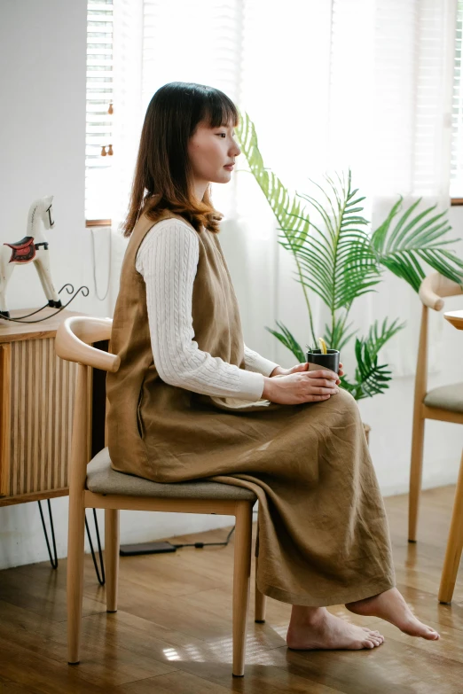 a person is sitting in a chair with a plant in it