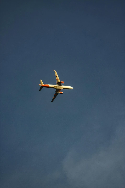 a plane flying in the air with a blue sky behind it