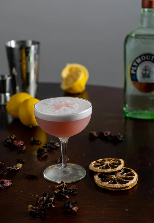 a drink garnished with a pink drink sitting next to the bottles