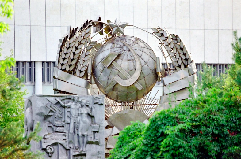 the sculpture is surrounded by many trees and shrubs