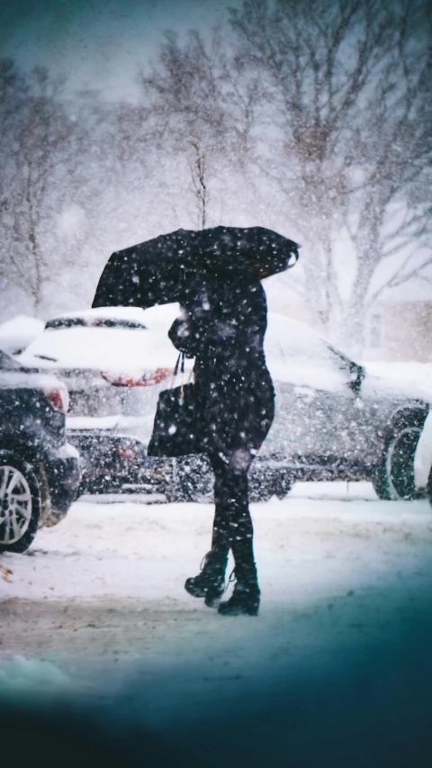 a woman in the snow holding a black umbrella