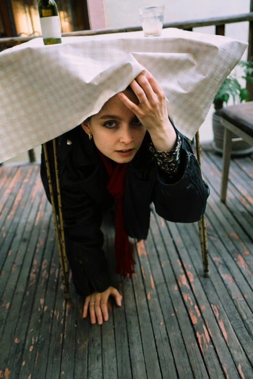 a woman sitting on the ground under a table