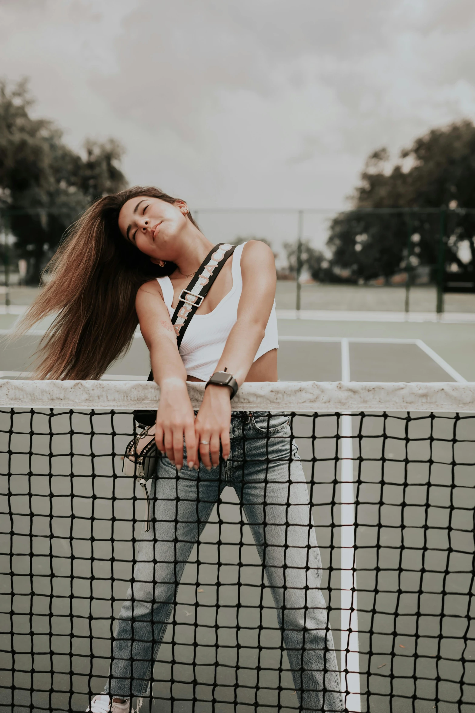 a woman is standing by the net on a tennis court