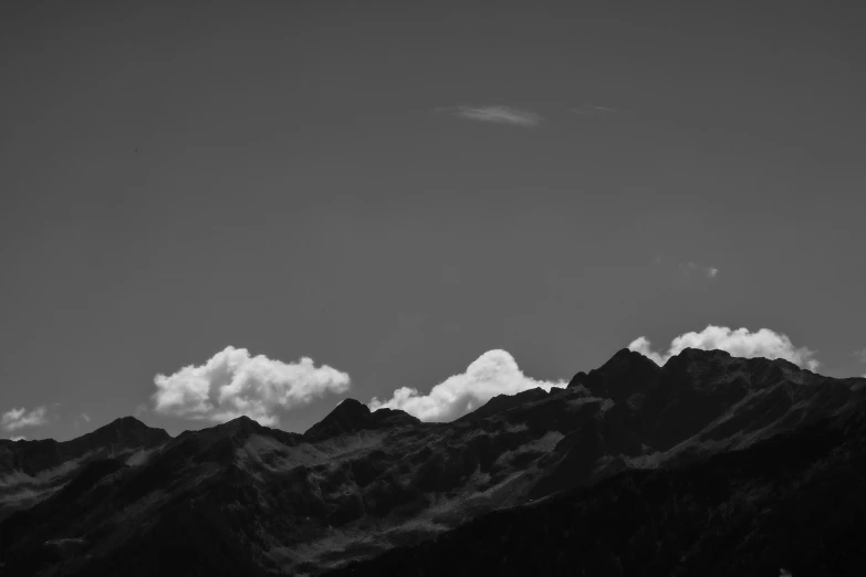 black and white pograph of the tops of a mountain with clouds