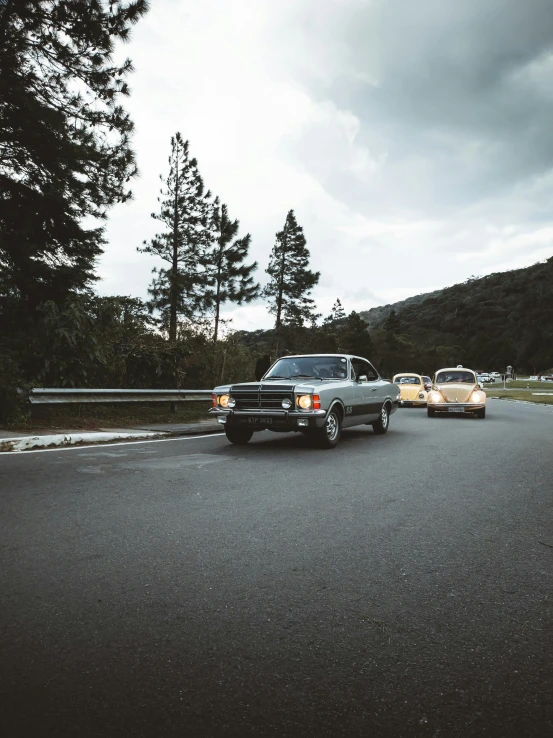 an old vintage car driving past a car on the road