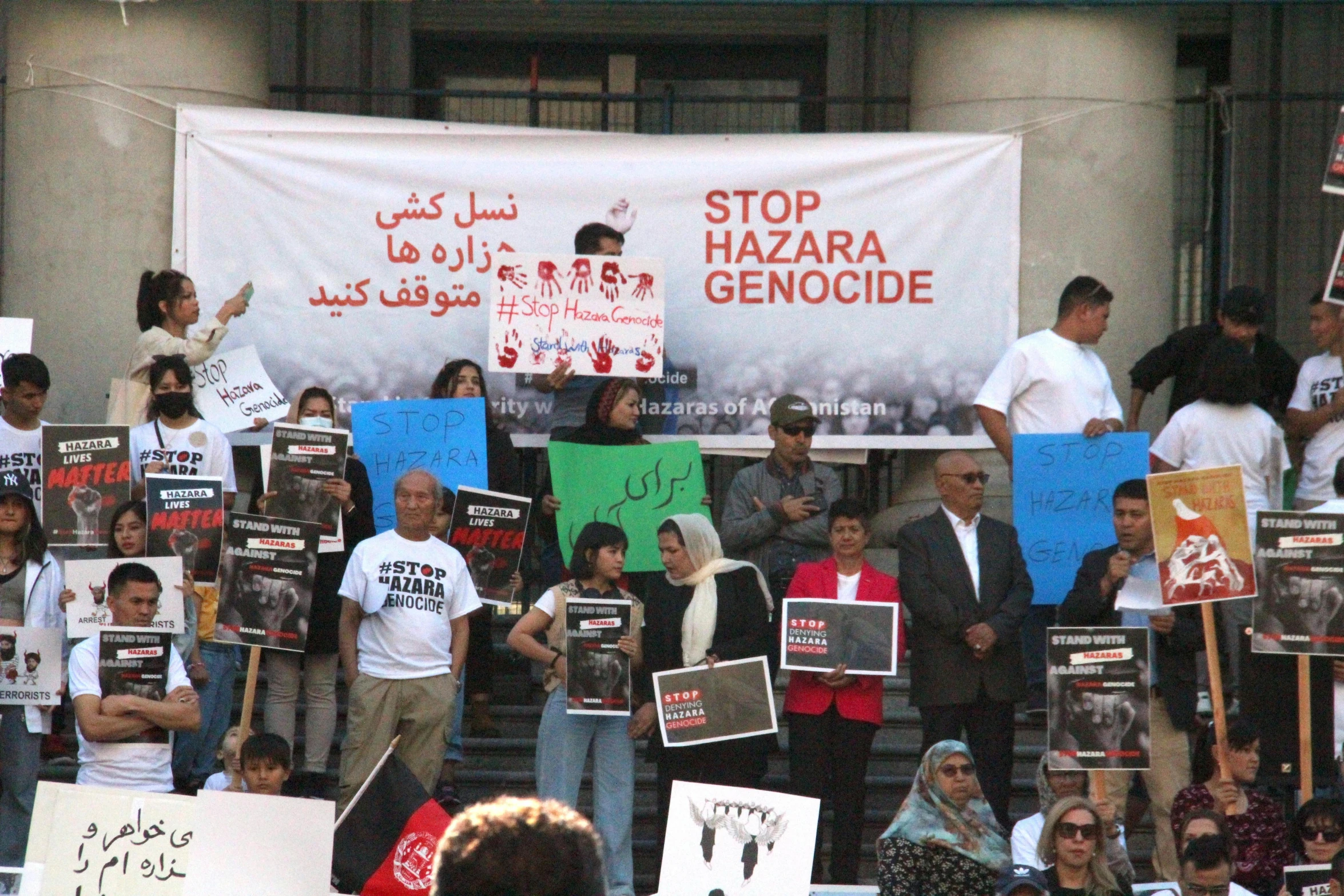 several people stand outside with protest signs