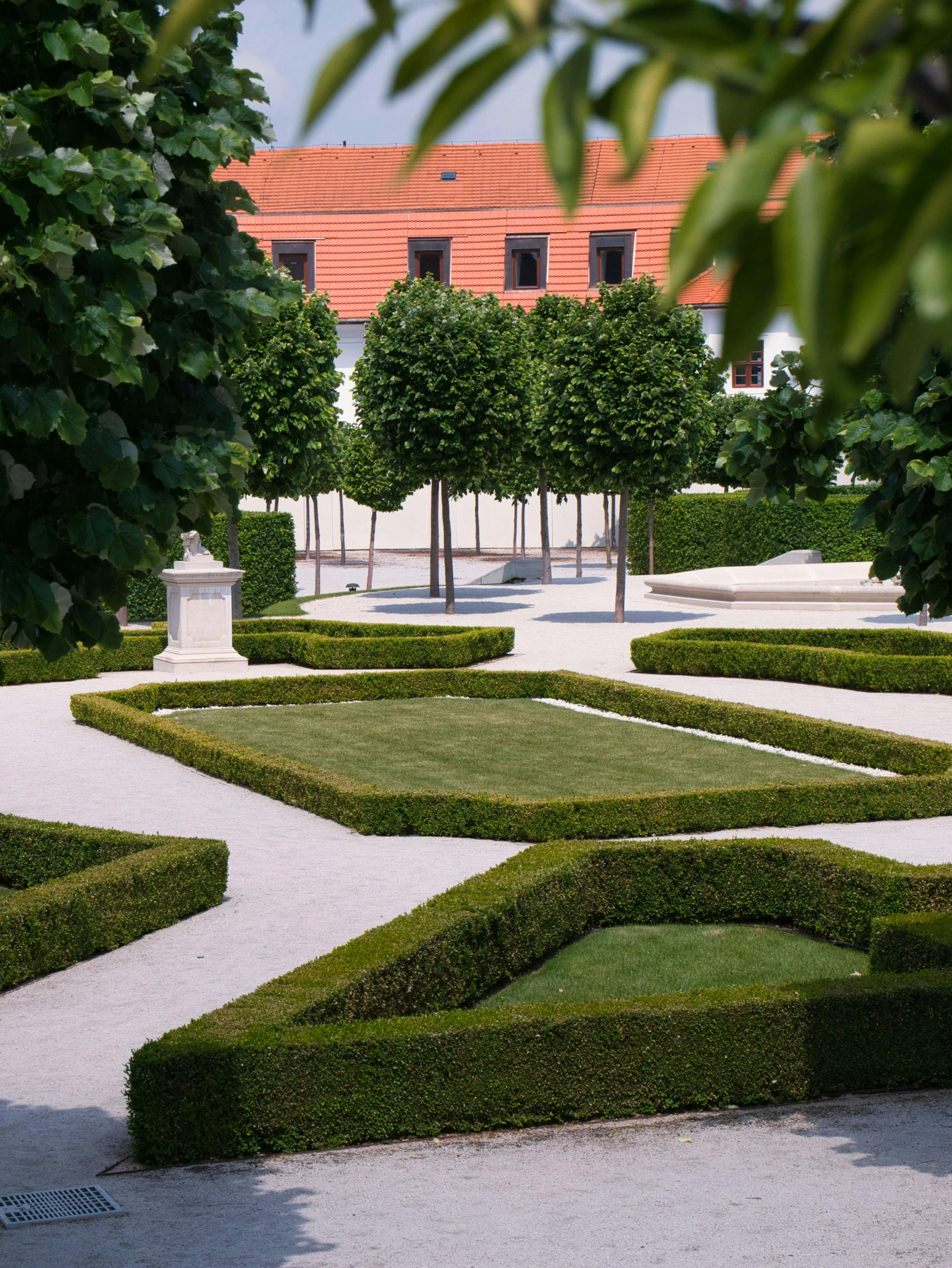 a square shaped area in between trees and a statue