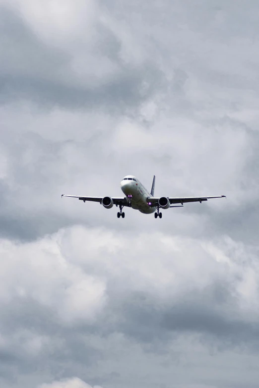 an airplane flying in the sky on cloudy day