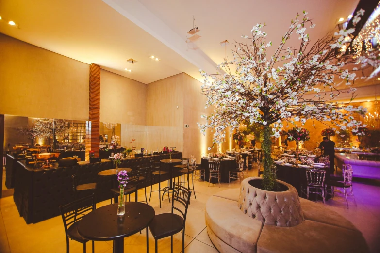 a banquet hall with black tables and white flowers