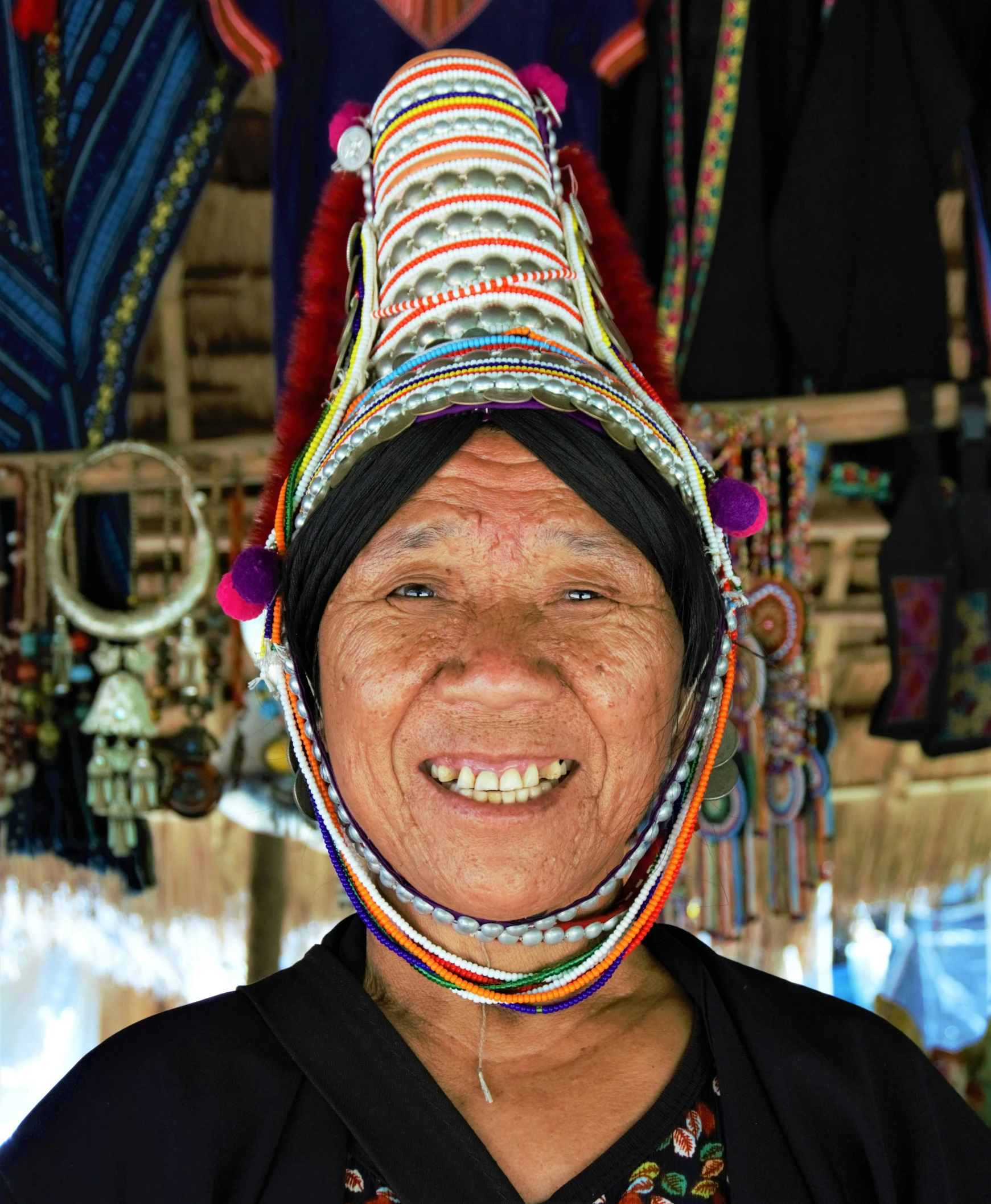 a women's headdress with beads and earrings is shown smiling