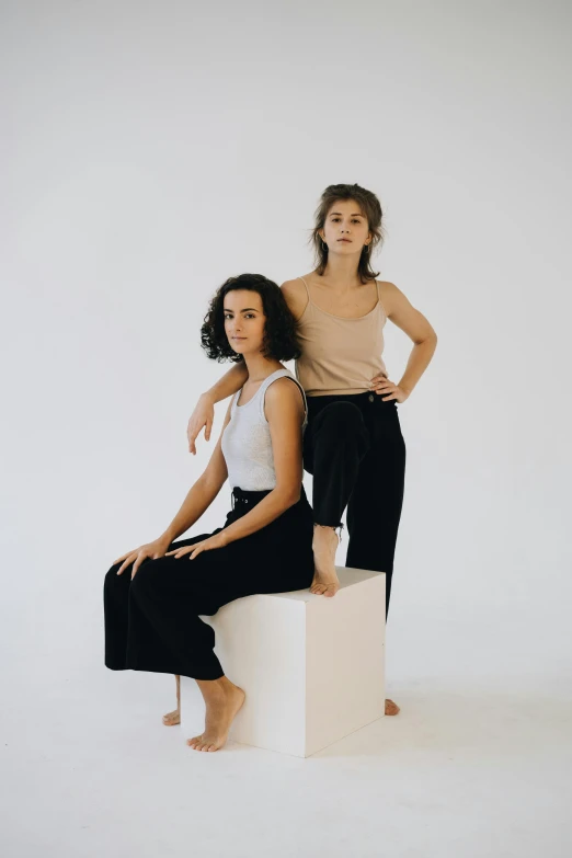 two women are posed against a white backdrop