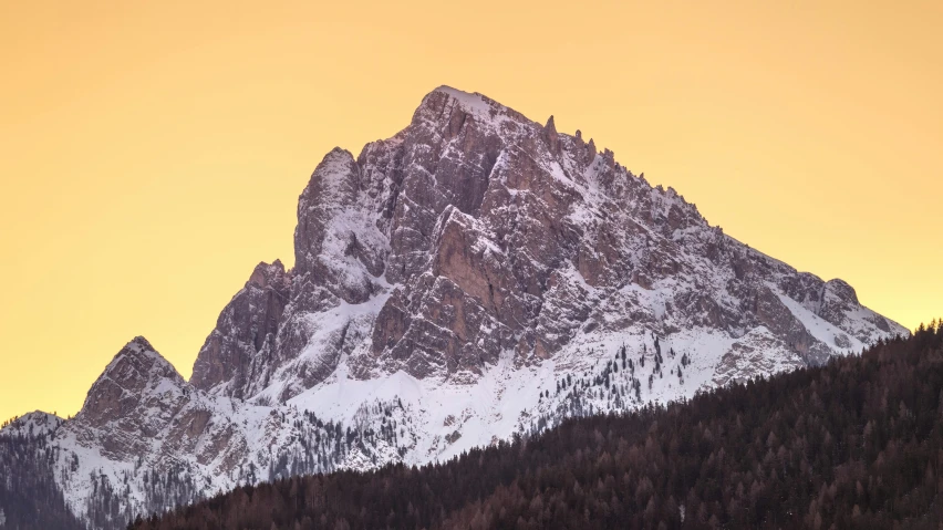 a majestic mountain has snow on it at dusk