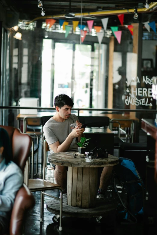 a man sits at a table in front of a plant