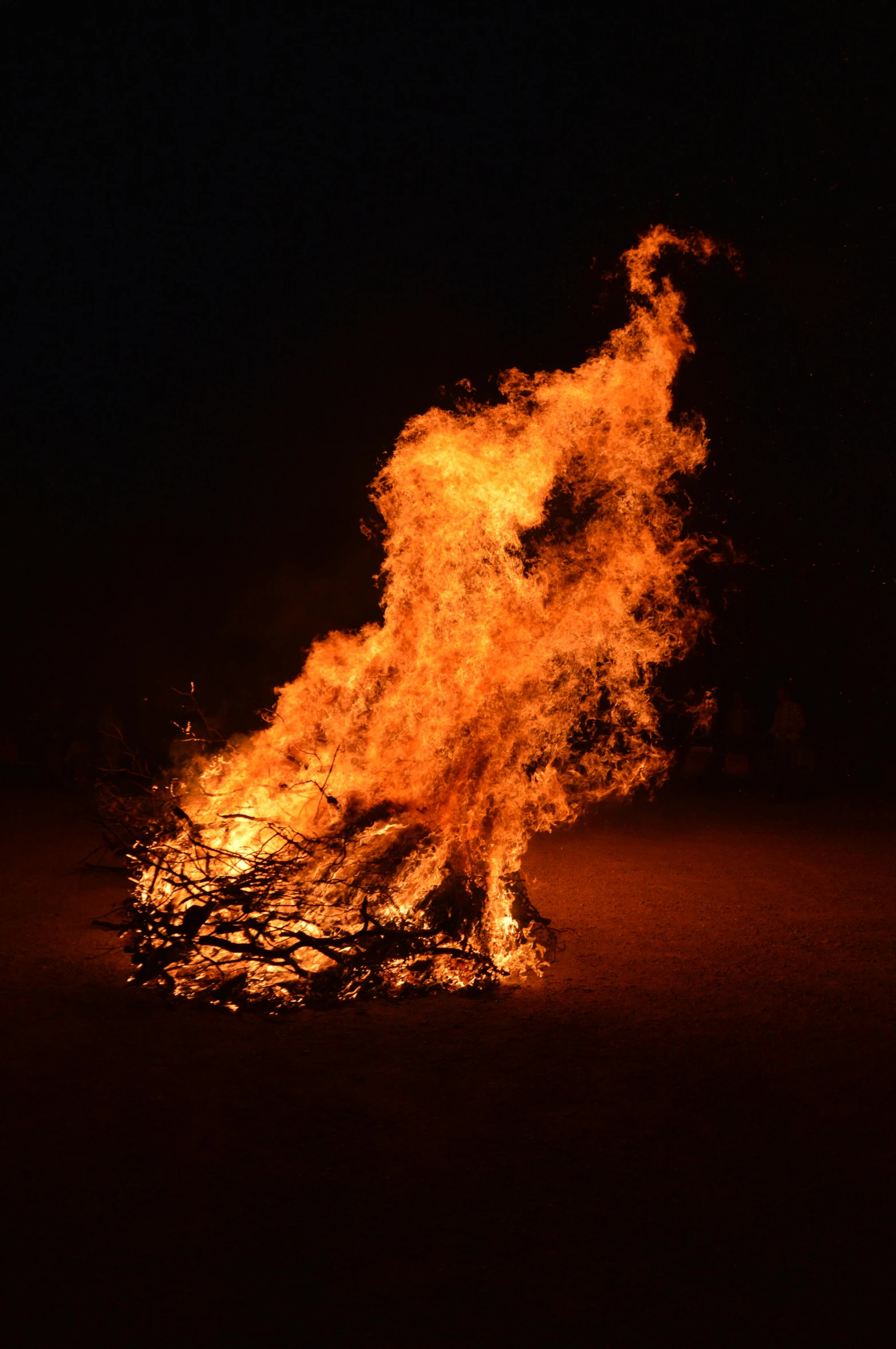 bright orange blazing fire is captured in a dark scene