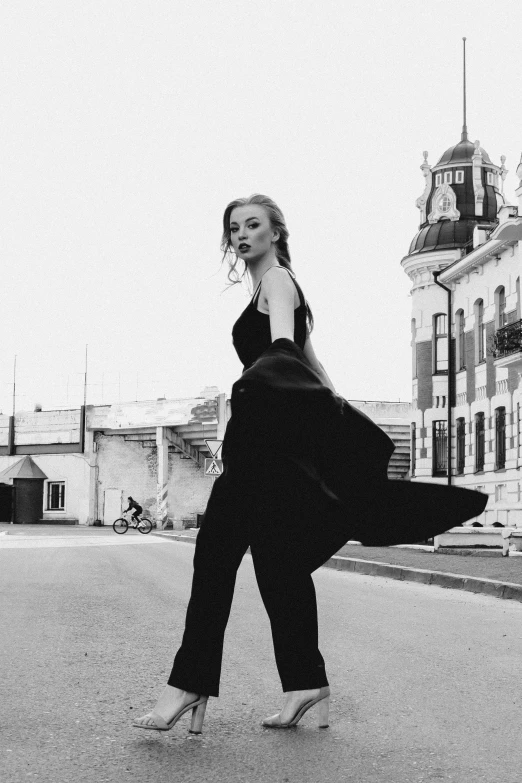 a black and white po of a woman in the middle of an empty street