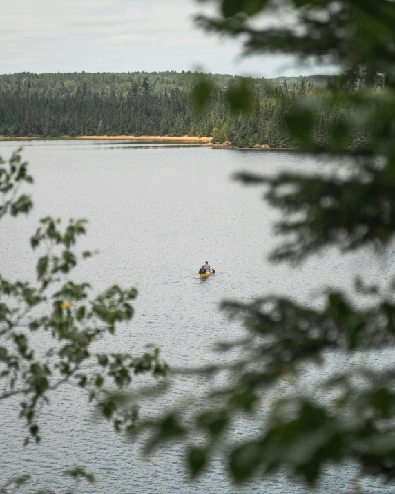 a view of a body of water with a man kayaking on it