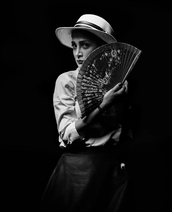 a woman with a hat holding a fan