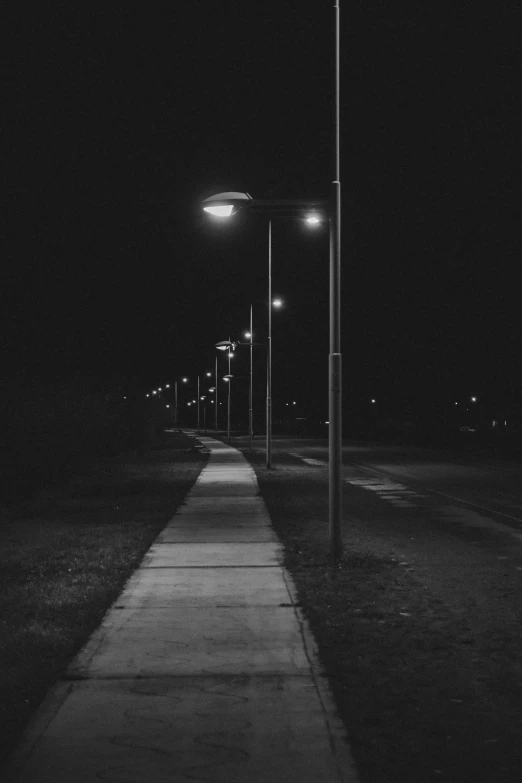 a walkway is at night in the dark with lights