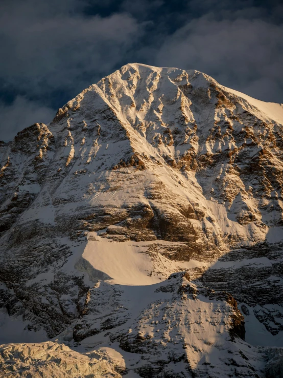 snow covered mountains are in the distance and dark clouds