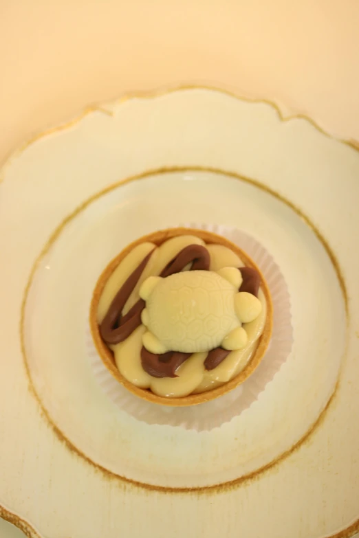 small desert items with a teddy bear and cream on a saucer