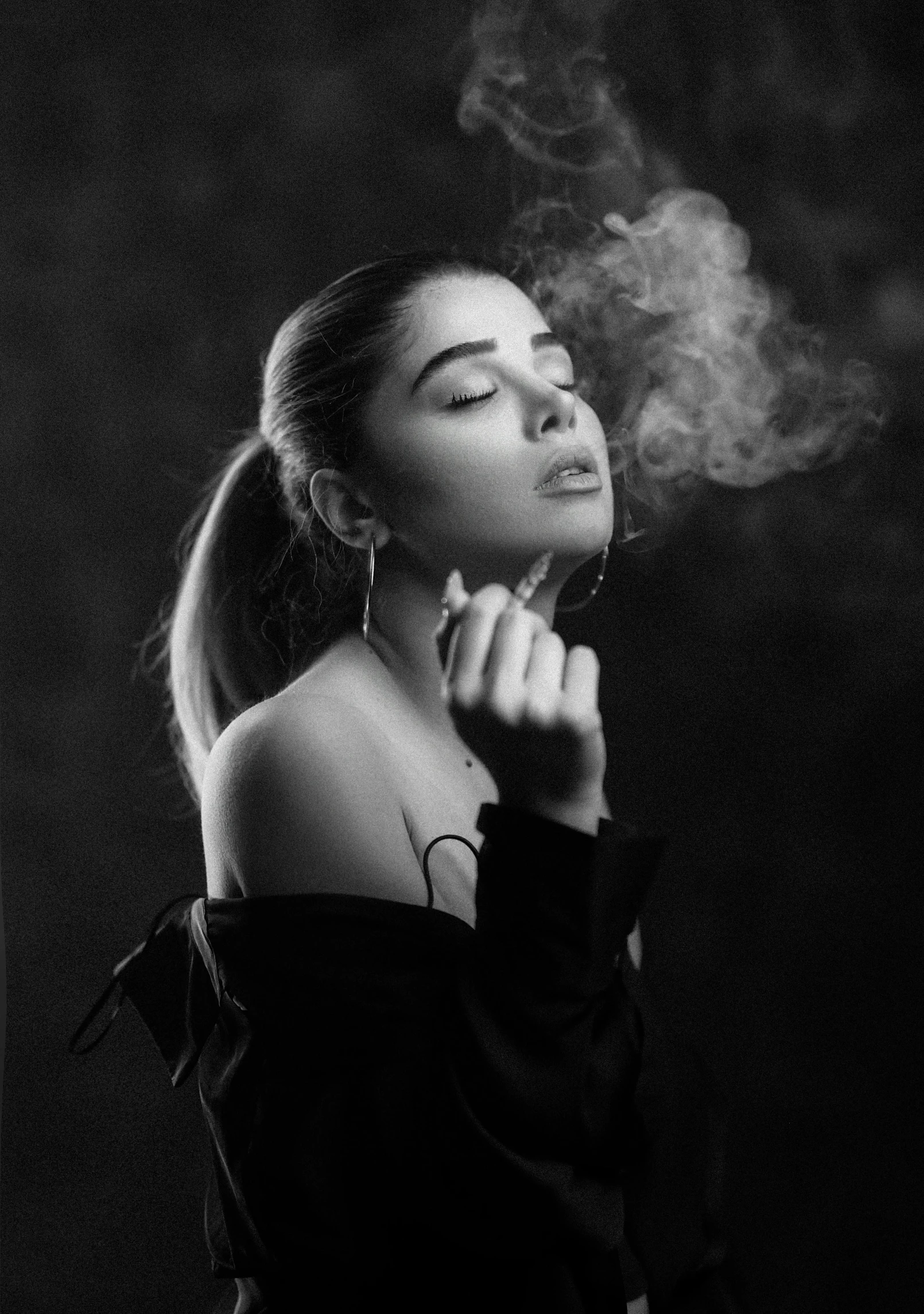 a young woman smoking and holding her head back