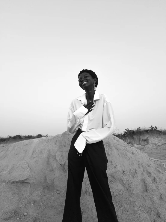 a young man standing in the sand on a cell phone