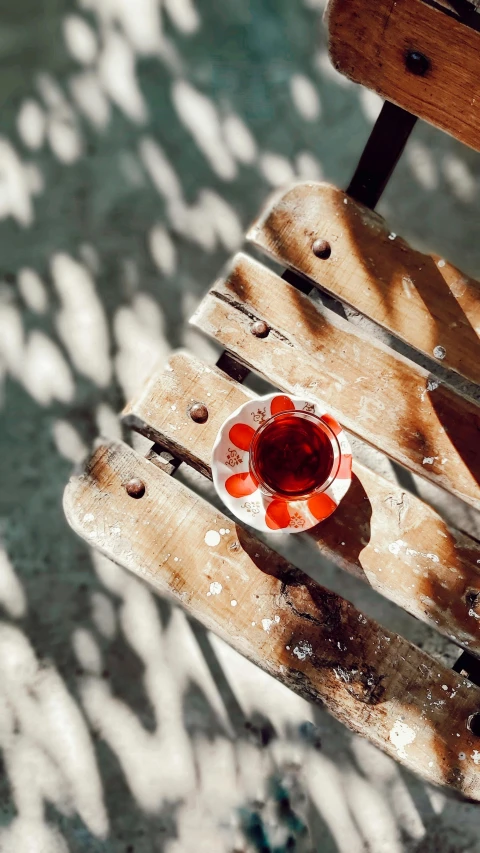 an orange cup sitting on top of a wooden chair