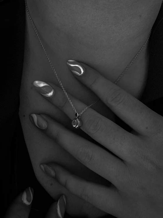 a woman holding on to a necklace and two rings