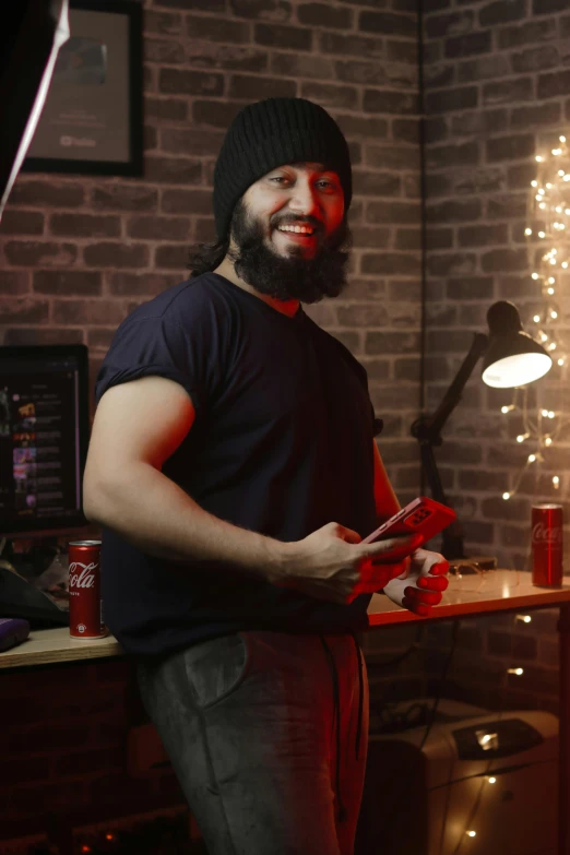 a man standing in a room next to a brick wall