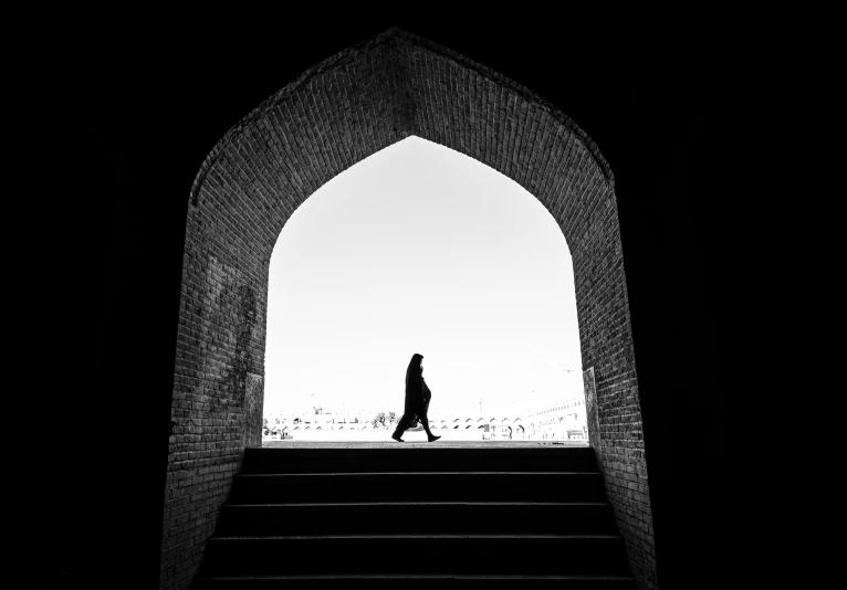 a silhouette of a woman walking up steps in the dark