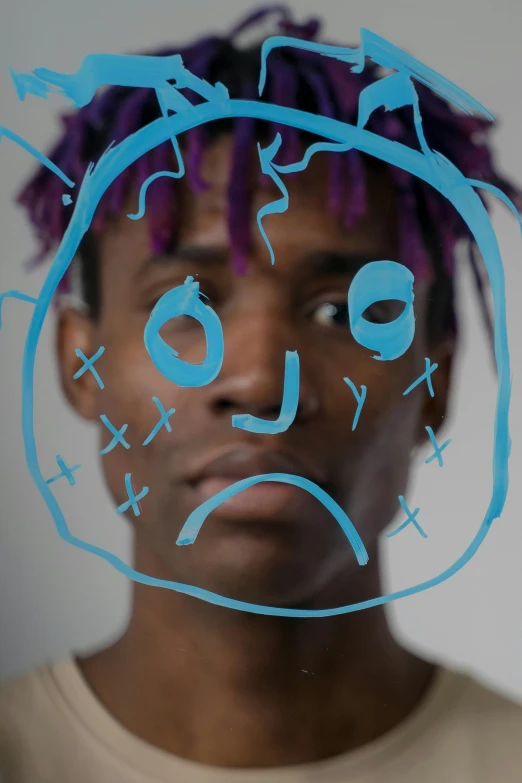 man with purple dreadlocks is making a strange face