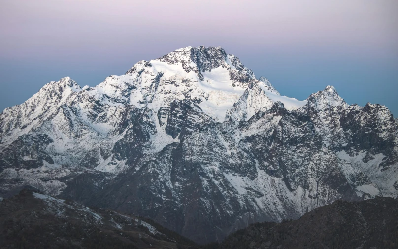 the mountains range covered in snow at twilight