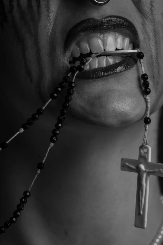 a cross being held up in the mouth of a woman