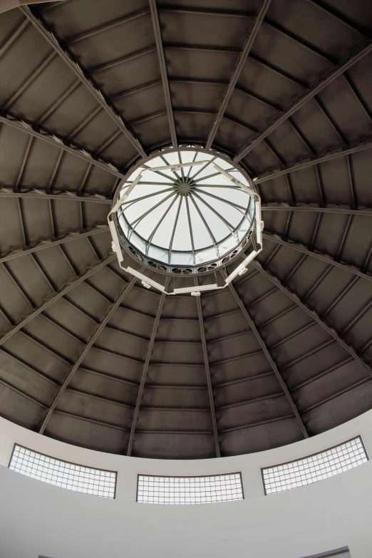 a man sitting under a circular structure looking up