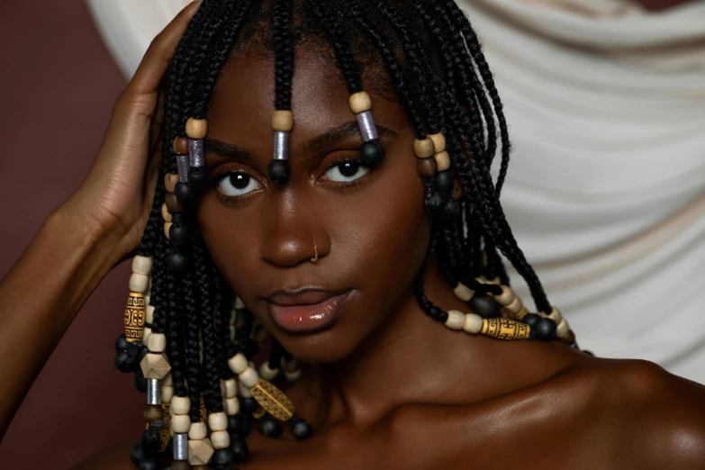 a woman is posed with different colored beads on her hair