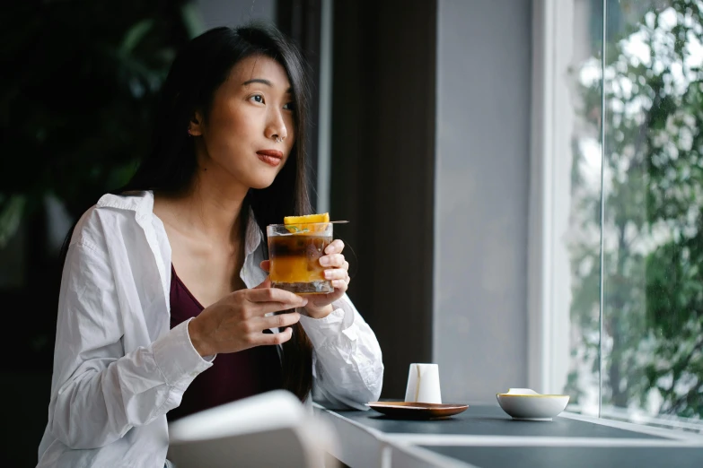 a woman drinking from a cup with a fork in her hand