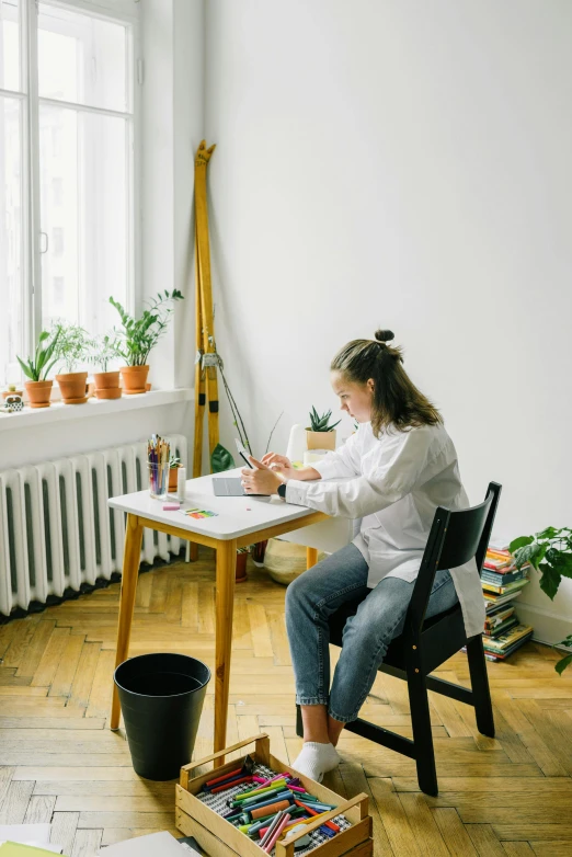 woman drawing and painting in her home with some plants