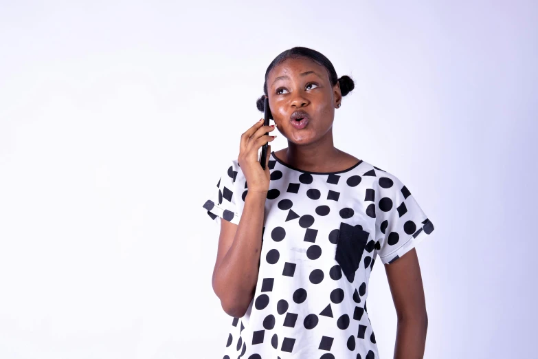 a woman wearing black and white polka dots talking on a cell phone