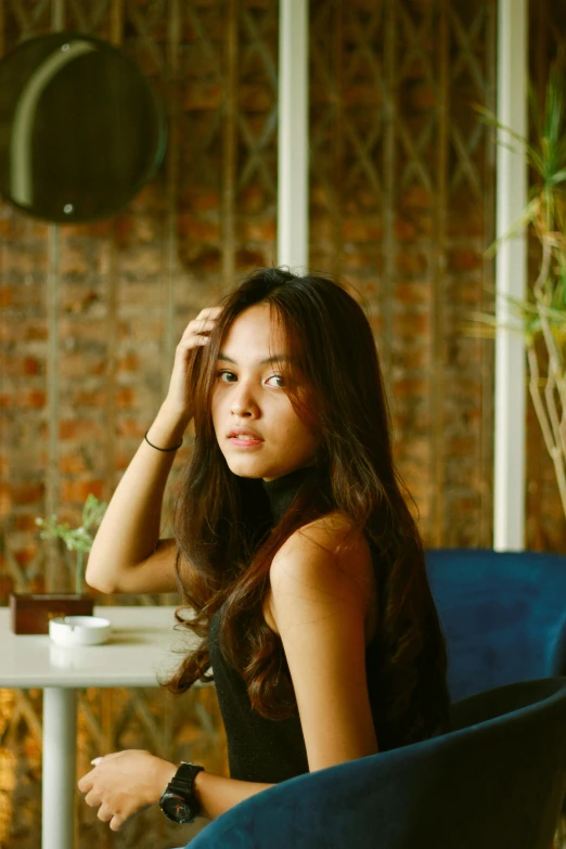 a woman in a black dress sitting at a table