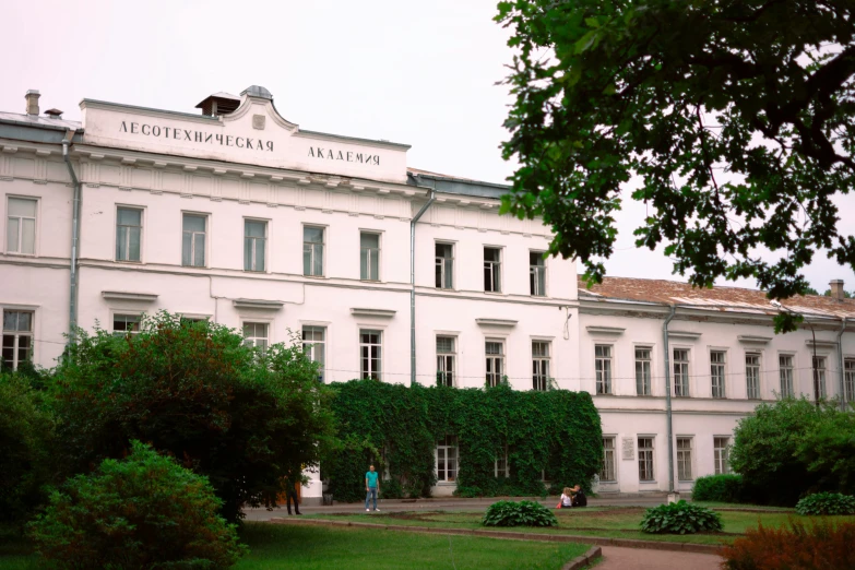 a large white building with many windows and many trees