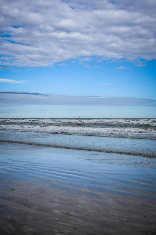 some water and sand under a blue sky