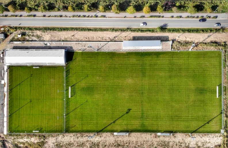 an aerial view shows an empty soccer field and buildings