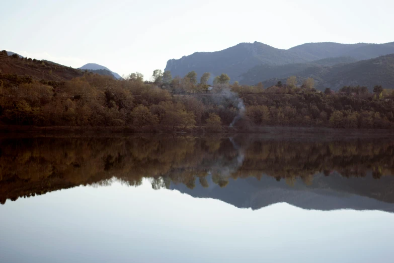 a river that has some clear water and mountains in the distance