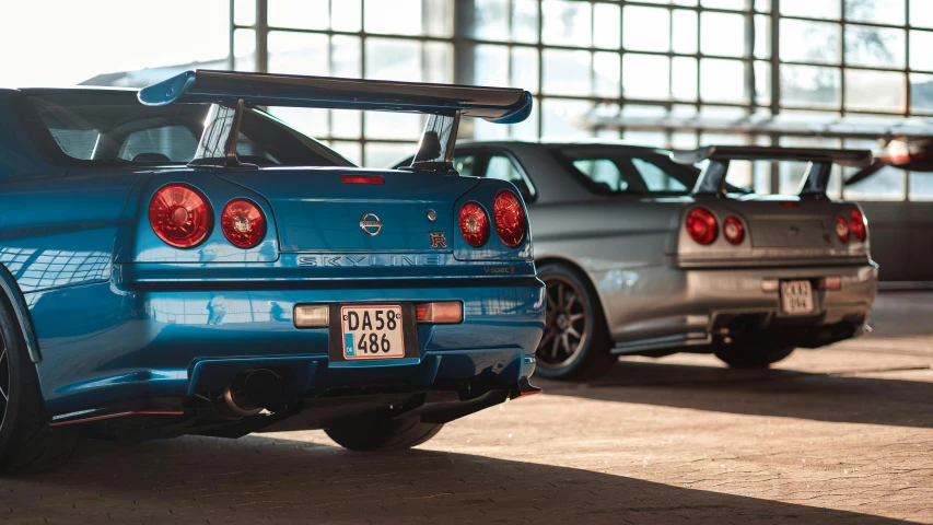 two blue cars parked side by side at a building